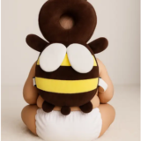 aby wearing Pink Uv bee head protector cushion while sitting indoor